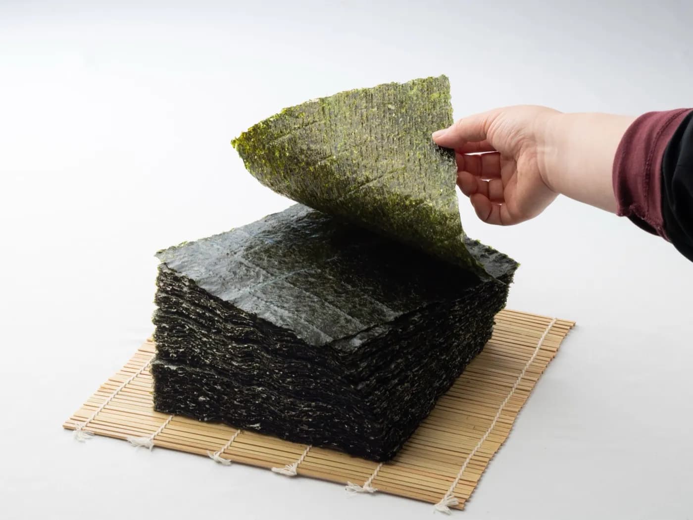 重ねた焼き海苔から一枚を手に取るところ