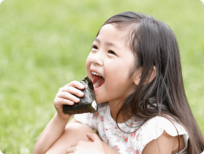 海苔を巻いたおにぎりを食べる子ども